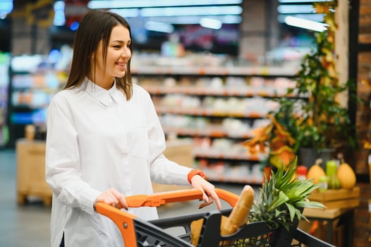 sale, shopping, consumerism and people concept - woman with food basket at grocery store or supermarket photo