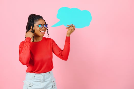 I Think. Pensive afro woman looking at blank speech bubble, touching her chin, copyspace, pink studio wall. photo