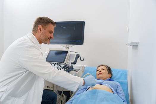 Male sonographer doing abdominal ultrasound scanning for patient in medical clinic photo