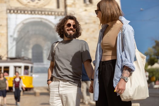 Smiling traveler couple walking on old city street background and holding hands photo