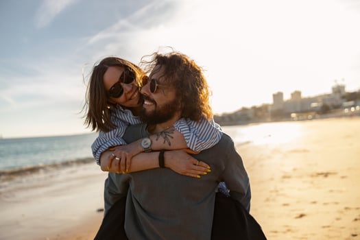 Handsome couple in love hugging while walking along the beach on sunny day photo