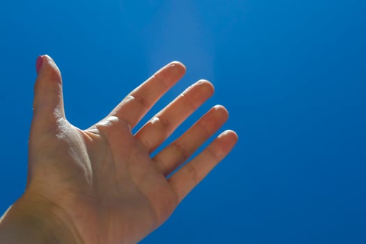 Female arm against a blue sky background. photo