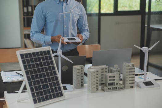Close-up at tablet, Engineers pointing at tablet with their hands. To jointly design the use of renewable energy with wind and solar energy. Concept of using renewable energy. photo