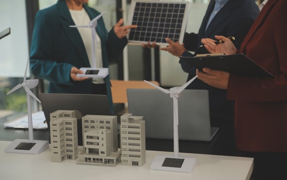Close-up at tablet, Engineers pointing at tablet with their hands. To jointly design the use of renewable energy with wind and solar energy. Concept of using renewable energy. photo