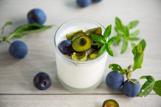 sweet homemade yogurt with fresh plum slices in a glass photo