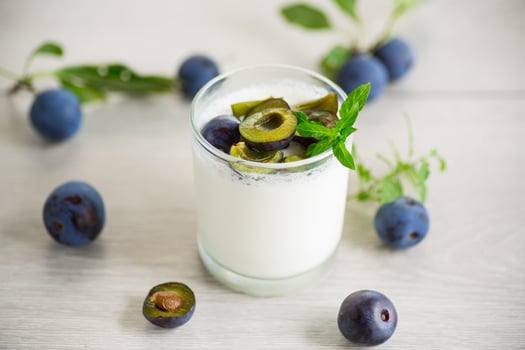 sweet homemade yogurt with fresh plum slices in a glass photo