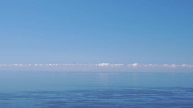 Aerial panoramic view of beautiful sunset above sea. Beautiful seascape. Sun glare, small waves on the water surface. Evening. Horizon. Nobody. No people. Never-ending beauty of nature. photo