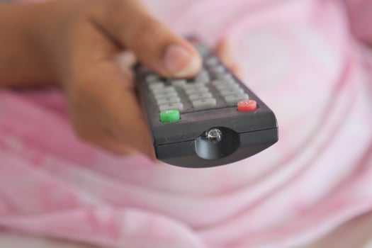 close up of women hand holding tv remote. photo
