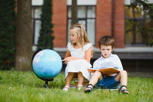 Happy children - boy and girl with books and backpacks on the first school day. Excited to be back to school after vacation. Full length outdoor portrait. photo