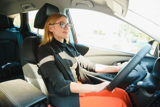 Beautiful mature woman in business suit driving a car to office. Businesswoman drive a car in city. photo