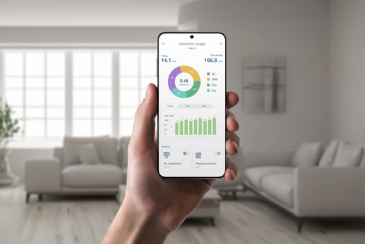 Hand holds smartphone with energy consumption app in living room interior. Concept of smart home technology and efficient energy management photo