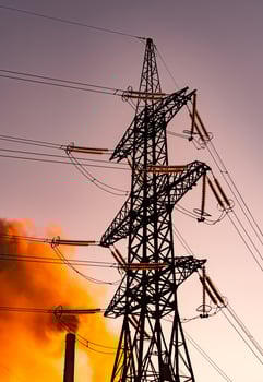 Electrical industrial distribution line. Silhouette of electric construction in orange sunlight. photo