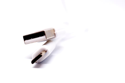A white usb cable with a white plug photo