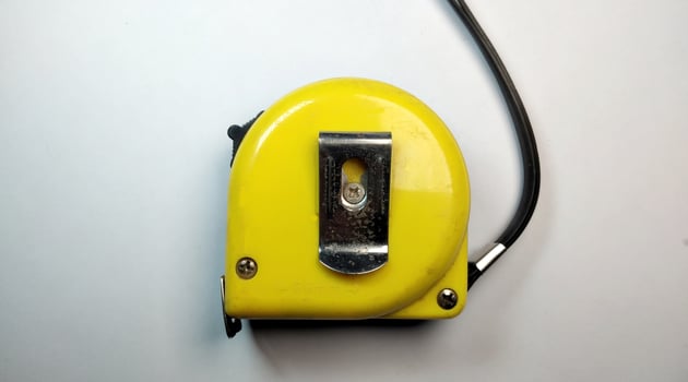 Yellow tape measure on a white background. Close-up. Selective focus. photo