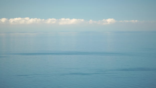 Aerial panoramic view of beautiful sunset above sea. Beautiful seascape. Sun glare, small waves on the water surface. Evening. Horizon. Nobody. No people. Never-ending beauty of nature. photo