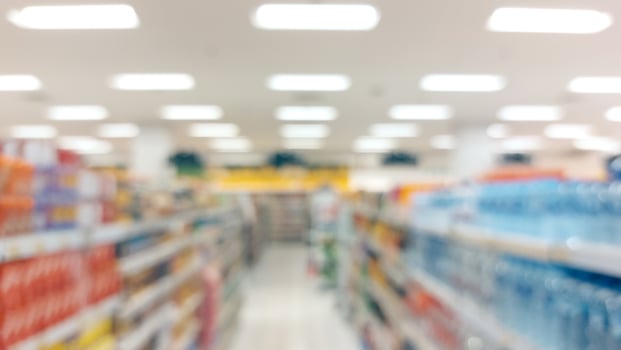 supermarket aisle and shelves blurred background. grocery store retail business concept photo