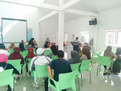 elderly people are sitting on green chairs queuing for health checks at the community health center. regular elderly health checks at semarang march 12 2024 photo