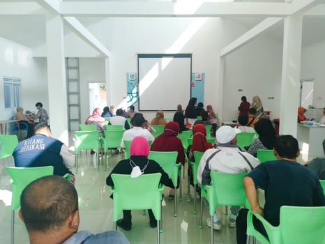 elderly people are sitting on green chairs queuing for health checks at the community health center. regular elderly health checks at semarang march 12 2024 photo