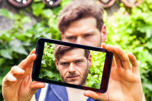 young millennial man taking a selfie with smart phone outdoors photo
