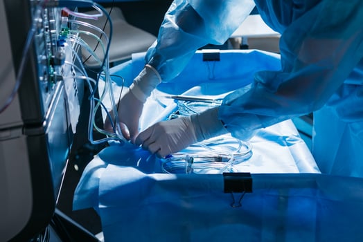 Doctor in personal protective kit Uses Medical Computer. Doctor connects wires, medical equipment, preparation before surgery in ophthalmology clinic photo