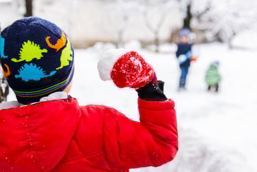 Little children playing with snowballs outdoor in the park photo