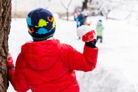 Little children playing with snowballs outdoor in the park photo