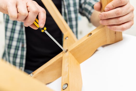 Self-assembly furniture concept. The young man himself assembling chairs photo