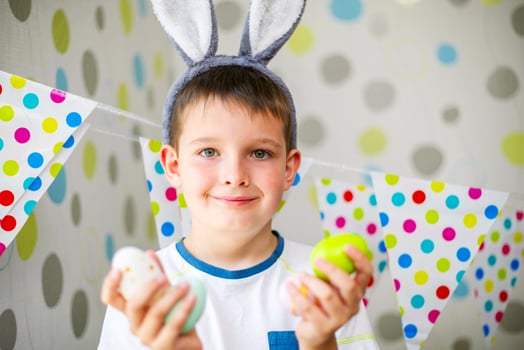 Cute boy with bunny ears holding Easter eggs. photo