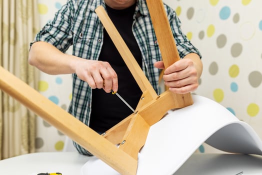 Self-assembly furniture concept. The young man himself assembling chairs photo