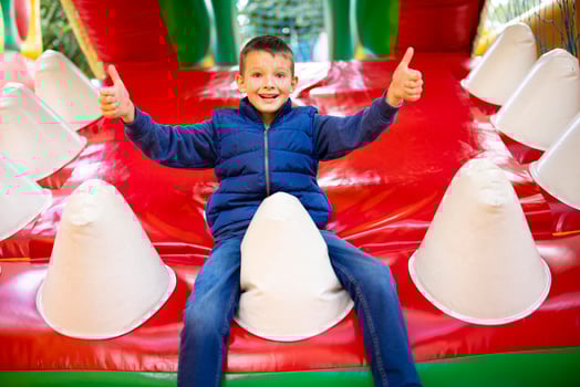 Happy boy having a lots of fun on a colorful inflate castle photo
