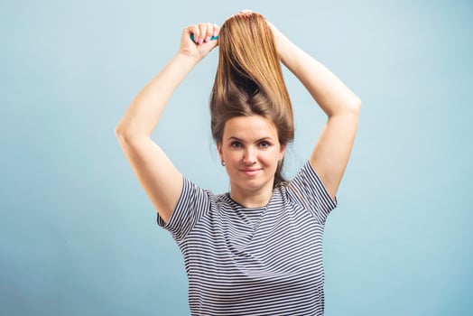 Beautiful brown-haired woman brushing her beautiful shiny hair with hairbrush photo