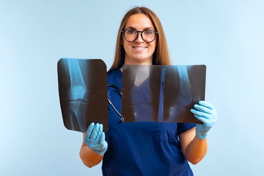 Woman doctor analyzes x-ray images of patients injured leg on a blue background photo