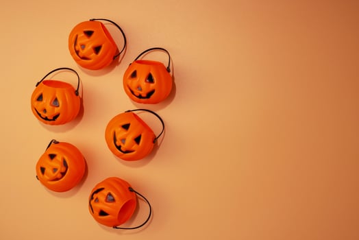 Flat lay composition with Halloween trick or treat buckets on orange background photo