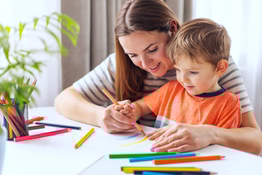 Young Mother Helps Son with Creative Drawing photo