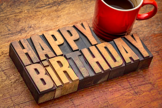 Happy Birthday greeting card - word abstract in vintage letterpress wood type blocks with a cup of coffee photo