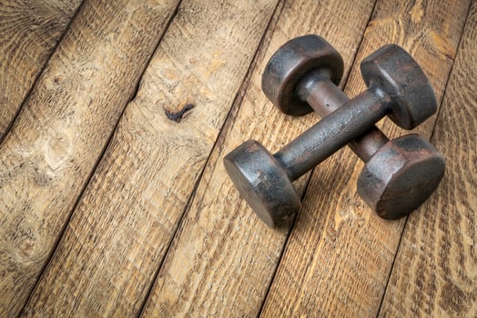a pair of vintage iron rusty dumbbells on a grained barn wood background, fitness concept photo