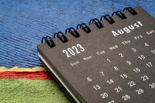 August 2023 - closeup of a small desktop calendar against abstract paper landscape, time and business concept photo