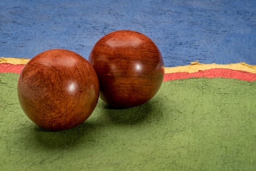 a pair of wooden Chinese medicine balls against colorful abstract paper landscape photo