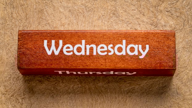 Wednesday and Thursday text on wooden block against handmade bark paper in earth tones, calendar concept photo