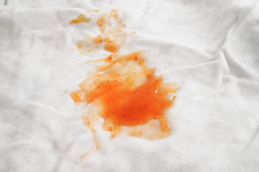 Dirty tomato sauce stain or ketchup on cloth to wash with washing powder, cleaning housework concept. photo