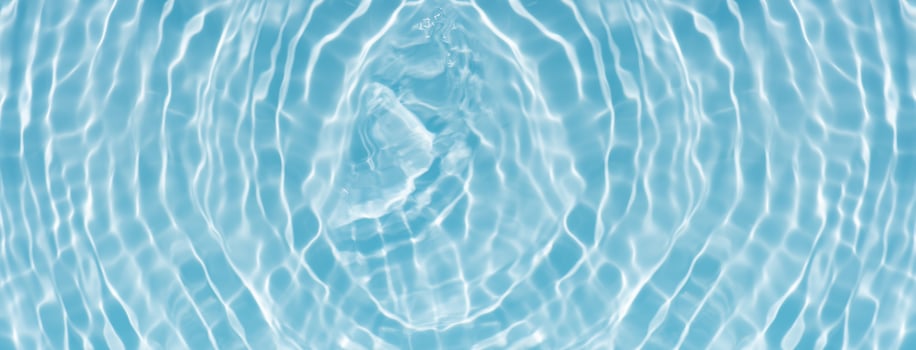 Bluewater waves on the surface ripples blurred. Defocus blurred transparent blue colored clear calm water surface texture with splash and bubbles. Water waves with shining pattern texture background. photo