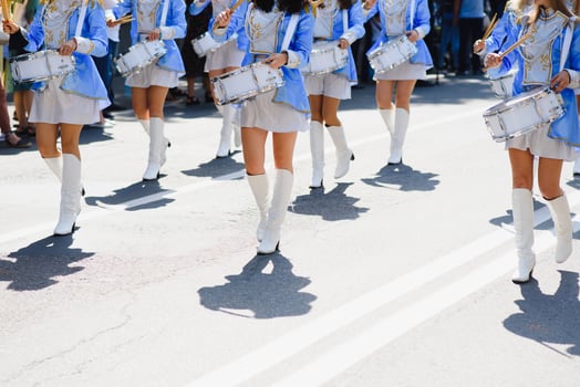 majorettes with white and blue uniforms perform in the streets of the city. photographic series photo