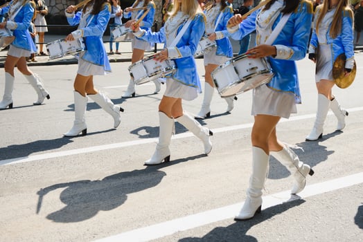 majorettes with white and blue uniforms perform in the streets of the city. photographic series photo
