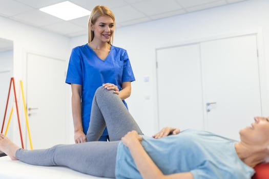 Physiotherapist working with patient in clinic, closeup. A Modern rehabilitation physiotherapy worker with senior client, Physical therapist stretching patient knee photo