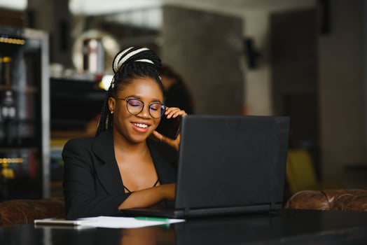 Young African American woman siting at cafe working on laptop photo