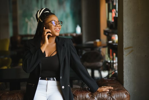 Young beautiful Afro-American businesswoman smart phone and smiling while working in cafe photo