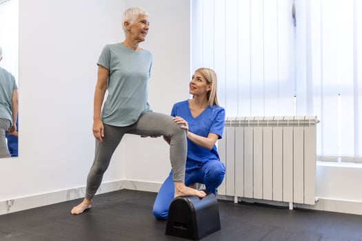 Senior patient at the physiotherapy doing physical exercises with her therapist, doing leg physiotherapy for elderly woman, to treat osteoarthritis and nerve pain in the leg. photo