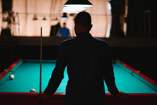 Young man playing billiard. Spending free time on gambling photo