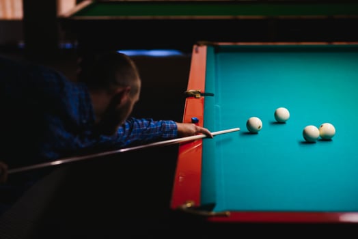 the player takes aim at the ball in Billiards photo