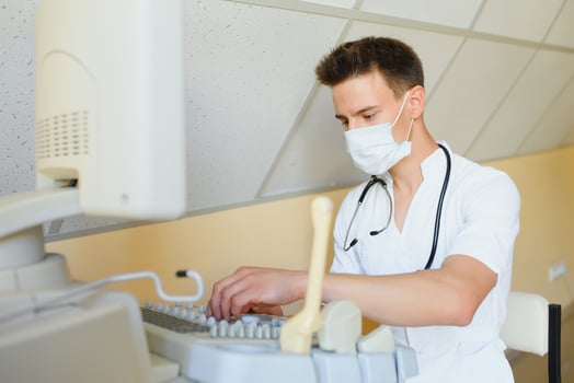 Portrait of young male technician operating ultrasound machine photo